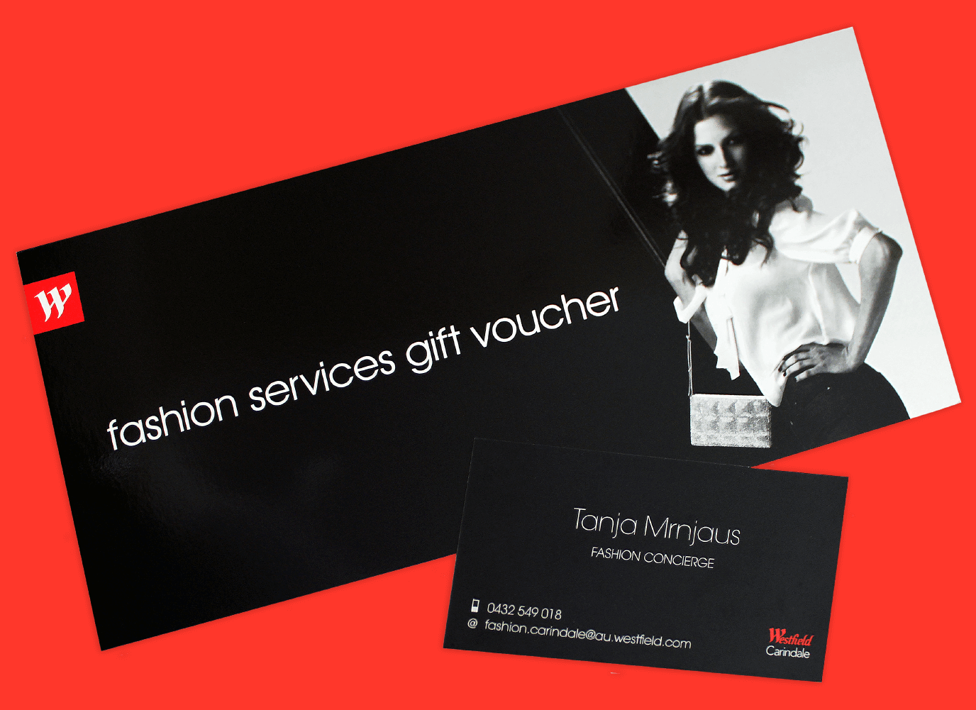 Glossy black DL sized, Westfield  gift voucher with a model in black and white posing at one end. A similar business card is also shown.